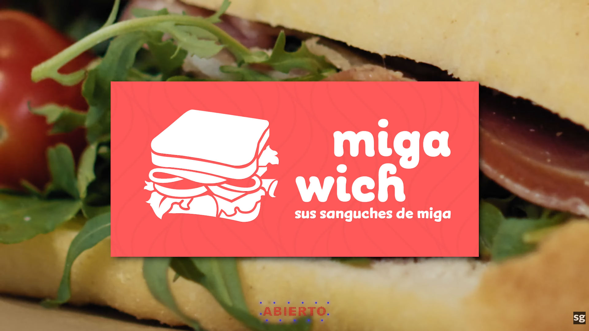 The final branding frame of a food commercial featuring the Miga Wich logo and a cinematic sandwich close-up.