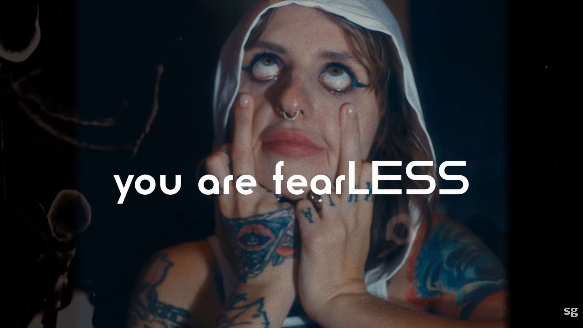 A gritty commercial frame of a woman in a hoodie with "You Are Fearless" text, demonstrating bold video editing for brand storytelling.